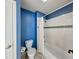 Bathroom showcasing a white tiled shower/tub, toilet, and modern blue wall paint at 9054 Cornucopia Dr, Indianapolis, IN 46268