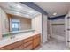 Bathroom featuring double vanity, a decorative mirror, and views into other rooms at 9054 Cornucopia Dr, Indianapolis, IN 46268
