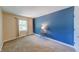 Spacious bedroom featuring blue accent wall, neutral carpeting, and natural light from a window at 9054 Cornucopia Dr, Indianapolis, IN 46268