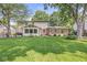 Expansive backyard featuring lush green lawn, mature trees, and a charming sunroom, perfect for relaxation and outdoor activities at 9221 Holyoke Ct, Indianapolis, IN 46268