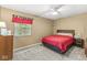 Cozy bedroom features neutral walls, plush carpet, ceiling fan and natural light from the window at 9221 Holyoke Ct, Indianapolis, IN 46268