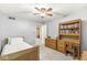 Well-lit bedroom features carpet flooring, a ceiling fan, and a convenient desk with shelving at 9221 Holyoke Ct, Indianapolis, IN 46268