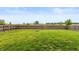 Large, grassy backyard featuring a wooden fence and a fire pit at 929 Capricorn Dr, Franklin, IN 46131