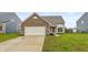 Charming single-Gathering home featuring a brick facade, attached garage, and lush green lawn at 929 Capricorn Dr, Franklin, IN 46131