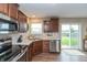 Well-lit kitchen with stainless steel appliances, wooden cabinets, and a view of the backyard at 929 Capricorn Dr, Franklin, IN 46131