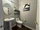 Bathroom with a pedestal sink, toilet, and wall decor at 9704 Gull Lake Dr, Indianapolis, IN 46239