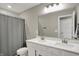 Bright bathroom featuring double sink vanity, large mirror, and shower with gray curtain at 9716 Cimmaron Ave, McCordsville, IN 46055