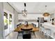 Elegant dining area adjacent to kitchen with modern lighting, dining table, and access to outdoor patio at 9716 Cimmaron Ave, McCordsville, IN 46055