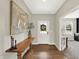 Inviting foyer with wood flooring, elegant console table, modern art, and view to a naturally lit office at 9716 Cimmaron Ave, McCordsville, IN 46055