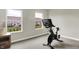 Bright exercise room with stationary bike and natural light from large windows at 9716 Cimmaron Ave, McCordsville, IN 46055