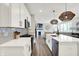 Bright kitchen with white cabinetry, stainless steel appliances, a center island, and open floor plan to the living area at 9716 Cimmaron Ave, McCordsville, IN 46055