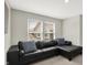 Comfortable living room features a plush black leather sectional sofa with window views at 9716 Cimmaron Ave, McCordsville, IN 46055