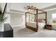 Bright main bedroom features a stylish four-poster bed, tray ceiling, and fan at 9716 Cimmaron Ave, McCordsville, IN 46055