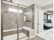 Walk-in shower with a bench, tile surround and glass doors near the main bedroom at 9716 Cimmaron Ave, McCordsville, IN 46055