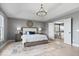 This bedroom boasts natural light, neutral walls, and an elegant chandelier above the well-appointed king bed at 10054 Win Star Way, Fishers, IN 46040