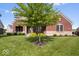 Beautiful brick and stone home featuring mature trees, lush lawn, and meticulously maintained landscaping at 10054 Win Star Way, Fishers, IN 46040