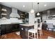 Well-appointed kitchen features a center island, dark cabinetry, granite countertops, and a stylish range hood at 10054 Win Star Way, Fishers, IN 46040