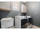 Well-equipped laundry room featuring modern washer, dryer, utility sink, and cabinet storage space at 10054 Win Star Way, Fishers, IN 46040