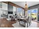 Stylish living and dining area with high ceilings, hardwood floors, a modern chandelier, and an adjacent patio at 10054 Win Star Way, Fishers, IN 46040