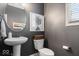 Stylish powder room featuring a pedestal sink, decorative mirror, and modern fixtures at 10054 Win Star Way, Fishers, IN 46040
