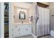 Bathroom features tile floors, a vanity with storage, and a shower/tub with patterned curtain at 102 Roxbury Ln, Noblesville, IN 46062