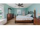 Bright bedroom with wooden floor, ceiling fan, large windows, and traditional furniture at 102 Roxbury Ln, Noblesville, IN 46062