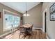 Well-lit dining room with hardwood floors, large window, and stylish light fixture at 102 Roxbury Ln, Noblesville, IN 46062