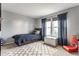 A cozy bedroom features a twin bed, patterned rug, and a bright window with navy curtains at 10273 Haag Rd, Brownsburg, IN 46112