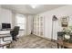Well-lit home office with a large window, patterned rug, and cozy seating area at 10273 Haag Rd, Brownsburg, IN 46112