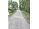 An unpaved alley is lined with mature trees and residences at 1030 N Concord N St, Indianapolis, IN 46222