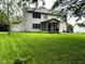 Spacious backyard with lush green lawn, a cozy screened porch, and an outdoor patio area at 10760 Independence Way, Carmel, IN 46032