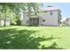 Well-maintained backyard shows the home's screened-in porch and verdant lawn at 10760 Independence Way, Carmel, IN 46032