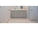 Bright bathroom with double sink vanity and white tile floors and walls at 10760 Independence Way, Carmel, IN 46032