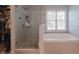 Modern bathroom featuring a separate glass shower and luxurious soaking tub with tile surround at 10760 Independence Way, Carmel, IN 46032