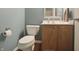 Cozy bathroom with a standard toilet, wooden vanity, and wall mirror at 10760 Independence Way, Carmel, IN 46032