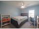 Bright bedroom with light blue walls, a ceiling fan, and a view of the outside from a window at 10760 Independence Way, Carmel, IN 46032
