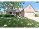 Charming home featuring a covered front porch, attached garage, and a well-manicured lawn at 10760 Independence Way, Carmel, IN 46032