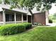 Beautiful brick home featuring a charming covered front porch and a well-maintained lawn at 10760 Independence Way, Carmel, IN 46032