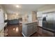 Open-concept kitchen with granite countertops, stainless steel appliances, and dark hardwood floors at 10760 Independence Way, Carmel, IN 46032