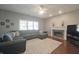 Comfortable living room with a fireplace, ceiling fan, and a plush sectional sofa at 10760 Independence Way, Carmel, IN 46032