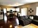 Open concept living room featuring hardwood floors, a comfortable sofa, and seamless kitchen access at 10760 Independence Way, Carmel, IN 46032