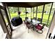 This screened-in porch features green outdoor views, a grill, and a table with four chairs at 10760 Independence Way, Carmel, IN 46032