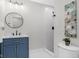 Stylish bathroom features modern vanity, round mirror, and shower with white tile at 11035 W Lakeshore Dr, Carmel, IN 46033