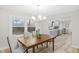 Dining room with wood floors, modern lighting, large window with view and open to the kitchen at 11035 W Lakeshore Dr, Carmel, IN 46033