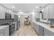 Modern kitchen featuring gray cabinets, stainless steel appliances, and open layout to dining area at 11035 W Lakeshore Dr, Carmel, IN 46033