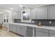 Beautiful kitchen with gray cabinets, stainless steel dishwasher, and a stylish herringbone backsplash at 11035 W Lakeshore Dr, Carmel, IN 46033
