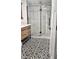 Modern bathroom with glass-enclosed shower, black and white tile, and wood vanity at 1125 S Drexel Ave, Indianapolis, IN 46203