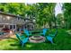 Lush backyard with a fire pit, Adirondack chairs, and a screened-in porch for relaxing and entertaining at 11510 Ralston Ave, Carmel, IN 46032