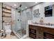 Bathroom showcasing a glass shower with stylish stone flooring, double vanity, and shelving for towels at 11510 Ralston Ave, Carmel, IN 46032