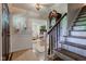 Inviting entryway with hardwood floors, staircase, and decorative accents, leading to the living area at 11510 Ralston Ave, Carmel, IN 46032